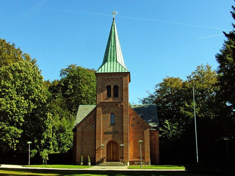 Bisættelser i Vedbæk kirke i Rudersdal Kommune med blå himmel